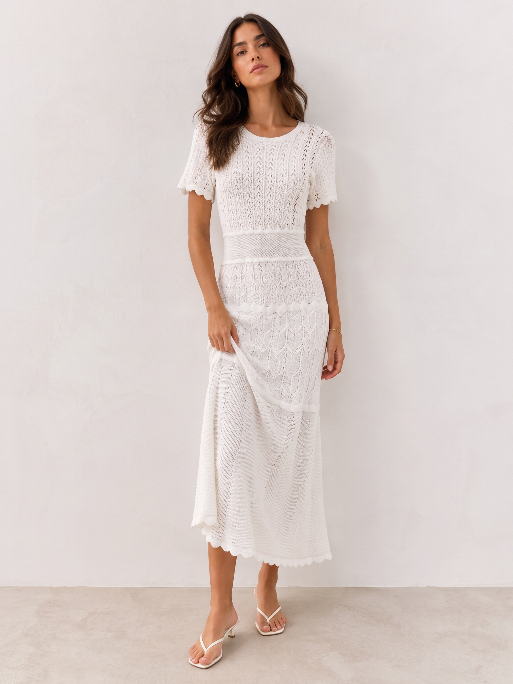 Vestido de tricô Noronha branco, de corpo inteiro, com a barra ondulada fechando a saia