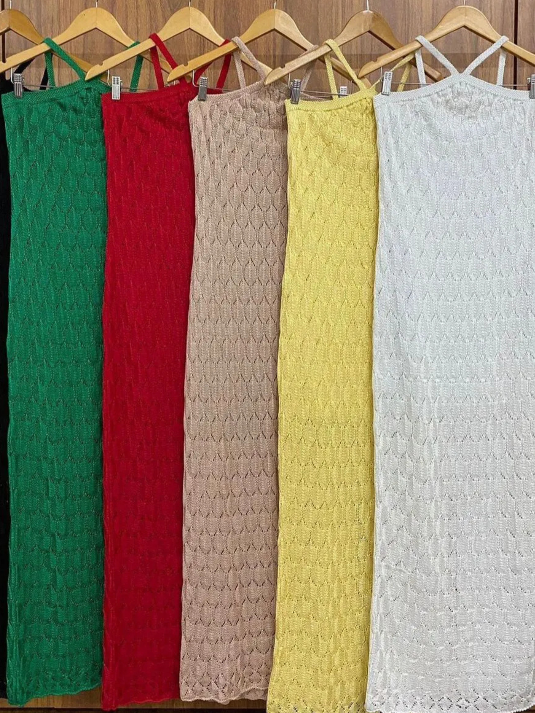 Vestidos de tricô Lyssa pendurados lado a lado, mostrando a trama em relevo